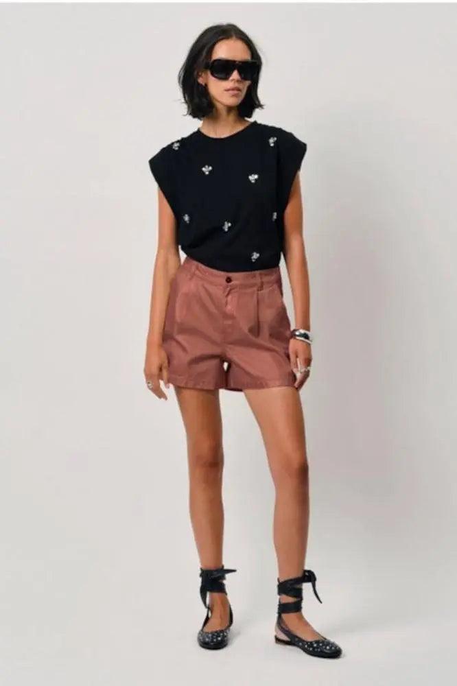 Dante6 Veralyn Shorts in Rose Metallic Biobaumwolle, kombiniert mit schwarzem Top und Sandalen.