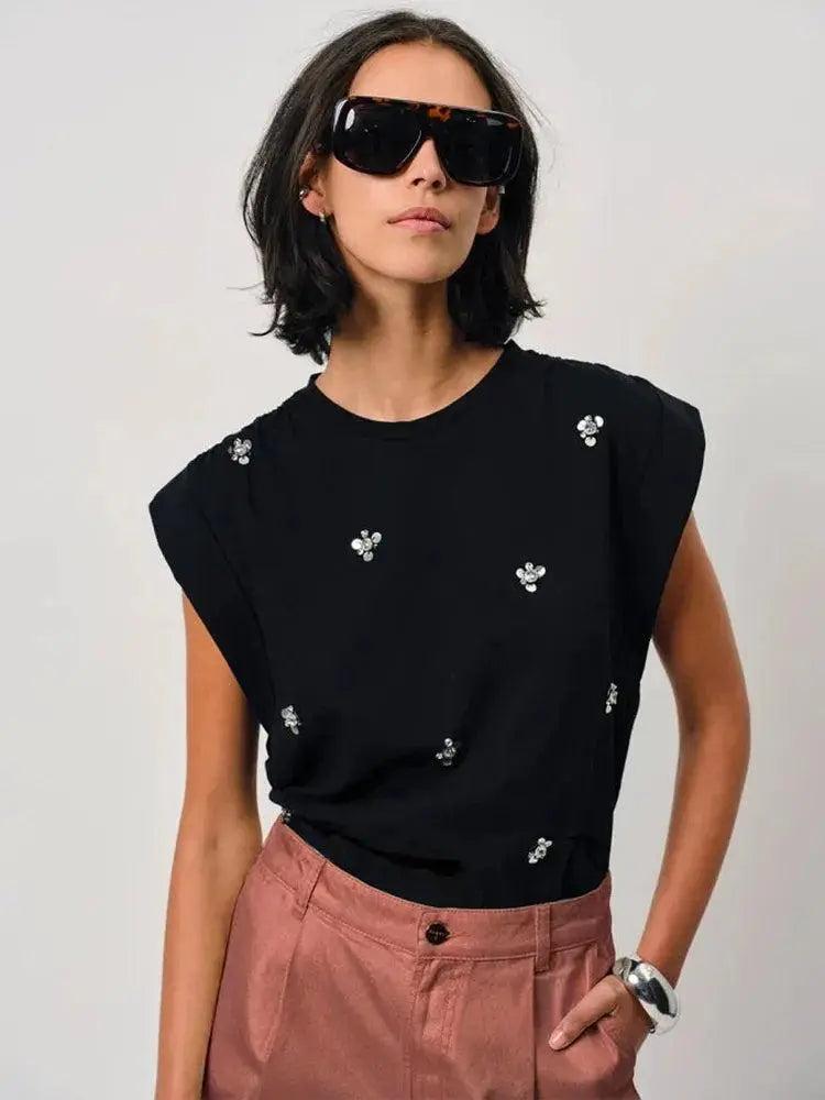 Model trägt Dante6 Shorts Veralyn in Rose Metallic mit schwarzem Top und Sonnenbrille.